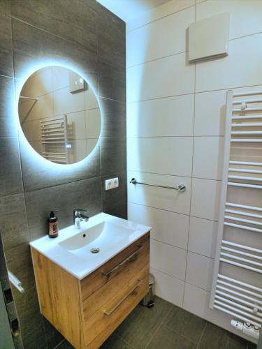 ein Badezimmer mit Waschbecken und Spiegel in der Unterkunft Jagerheim Apartments Flattach in Flattach