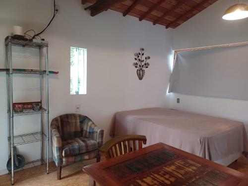 a living room with a table and a chair at Sopro da Serra Chalé Papagaio in Gonçalves