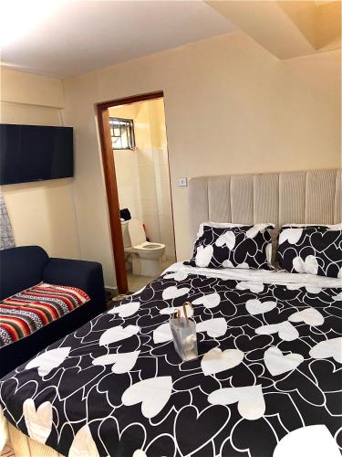 a bedroom with a black and white bed and a couch at Rees haven in Nanyuki