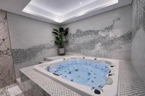 a bathroom with a jacuzzi tub with a plant in it at 5 Star High Rise Luxury Apartment, Infinity Pool With Stunning Burj View - Brand New Apartment in Dubai