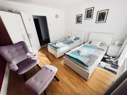 een slaapkamer met een bed en een stoel erin bij Apartman Šimić in Gračac