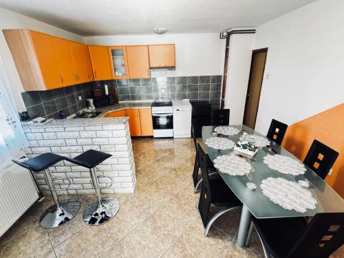 a kitchen with a dining table and a kitchen with orange cabinets at Apartman Šimić in Gračac