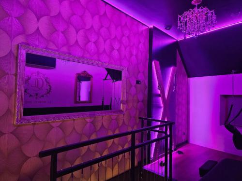 een paarse kamer met een spiegel en een trap bij La secrète room in La Mure