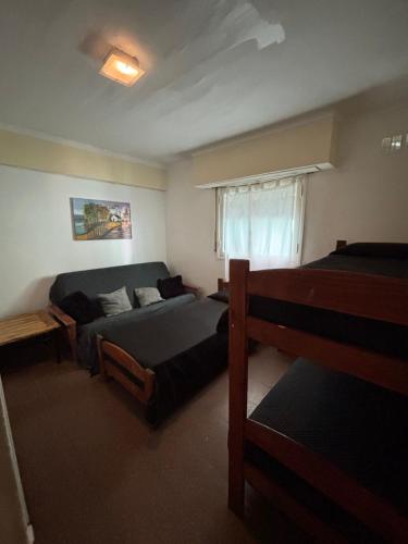 een slaapkamer met een bed en een bank bij Hotel gade in Mar del Plata