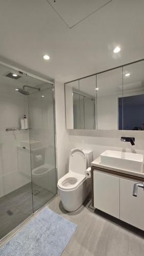 a bathroom with a toilet and a shower and a sink at FV 1BR APT with Rooftop Pool in Brisbane