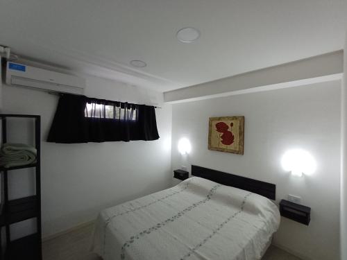 una piccola camera da letto con un letto e una finestra di La Villa Inn a Villa Carlos Paz