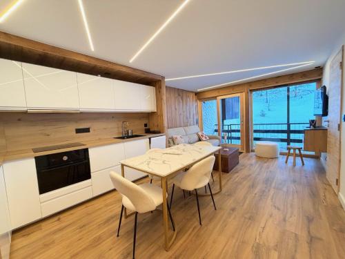 eine Küche und ein Wohnzimmer mit Tisch und Stühlen in der Unterkunft T3 sur les pistes - Les Claux in Vars