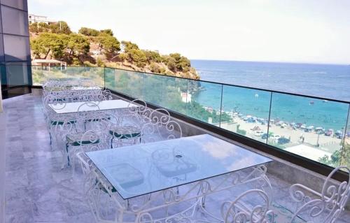 a balcony with tables and chairs and the ocean at HOTEL Diar Jenna in Annaba