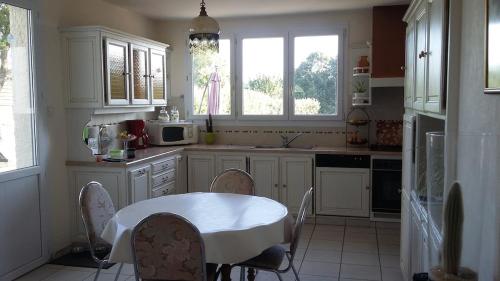 a kitchen with a table with chairs and a microwave at Les chataigniers in Apremont