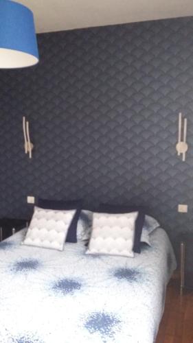 a bedroom with a white bed with a black wall at Les chataigniers in Apremont