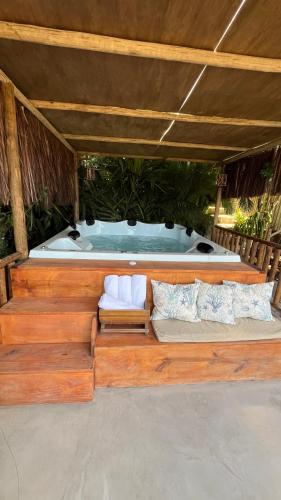 a bench in front of a jacuzzi tub at Eliza, Bangalô vista mar em Trancoso in Trancoso