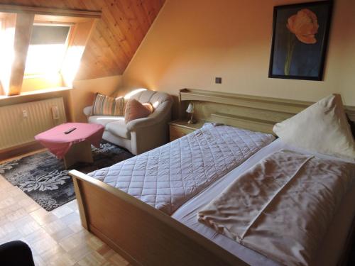 une chambre avec un lit et une chaise dans l'établissement Ferienwohnung für Handwerker, à Kappeln