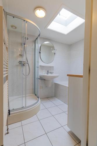 a bathroom with a shower and a sink at Beach & Bunker in Hollum