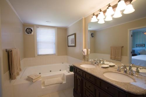 a bathroom with a tub and two sinks and a bath tub at Maplewood Hotel in Saugatuck