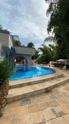a swimming pool in a yard with a stone wall at Refúgio das Thermas in Caldas Novas