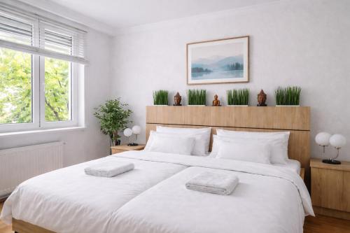 een slaapkamer met een groot wit bed met twee kussens bij Comfort 28 Great Value Apartment in Miskolc