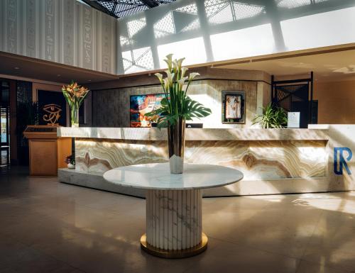 a table with a plant on it in a lobby at Retac Abu Simbel Nefertari Hotel in Abu Simbel