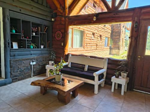 ein Wohnzimmer mit Sofa und Tisch in der Unterkunft El Refugio in Aluminé