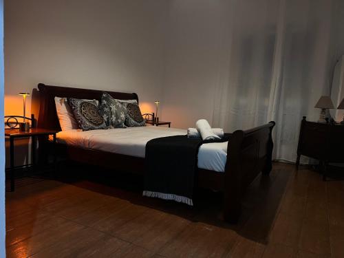 a bedroom with a bed and two tables and a lamp at ARTEMIS HOUSe in Kakopetria