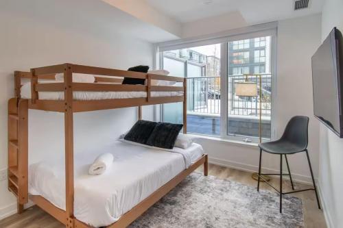 een slaapkamer met een stapelbed en een stoel bij PET FRIENDLY CONDOS at FRIDAY HARBOUR in Innisfil