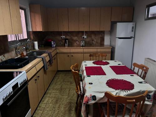 a kitchen with a table and a white refrigerator at ARTEMIS HOUSe in Kakopetria