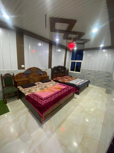 ein Zimmer mit zwei Betten und einem Stuhl in der Unterkunft Shri Ladli Ji Guest House in Chhatikara