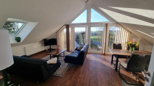 a living room with a table and chairs and a large window at Casa La Vie Ferienwohnungen in Altenstadt