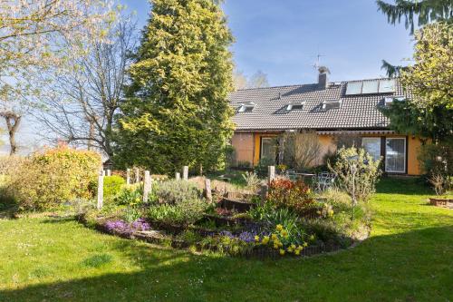 a house with a garden in front of it at Casa La Vie Ferienwohnungen in Altenstadt
