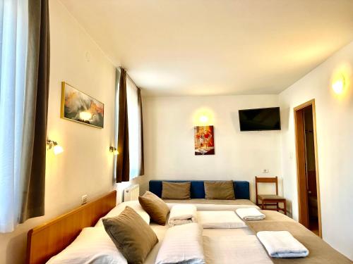 una stanza con due letti e un divano di Garni Hotel Keltika a Izola