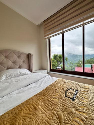 a bedroom with a large bed with a large window at İsgobya Dağ Evleri 101 in Macka
