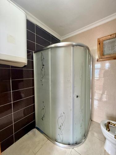 a metal shower in a bathroom with black tiles at İsgobya Dağ Evleri 101 in Macka