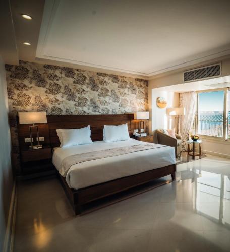 a bedroom with a large bed and a large window at Retac Abu Simbel Nefertari Hotel in Abu Simbel