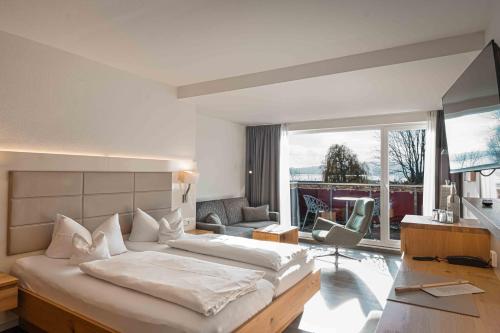 een slaapkamer met een groot bed en een woonkamer bij Hotel Lipprandt in Wasserburg