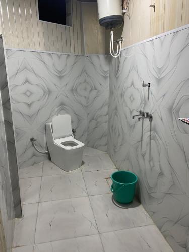 ein Badezimmer mit Toilette und Waschbecken in der Unterkunft Shri Ladli Ji Guest House in Chhatikara