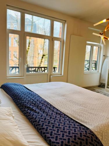 a bedroom with a bed with a blue blanket on it at l'imperial WIFI & Confort in Brussels