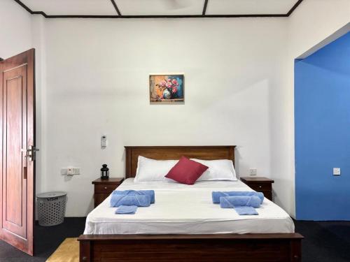 een slaapkamer met een bed met blauwe handdoeken erop bij Sea Breeze Stay in Negombo