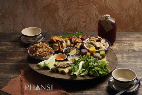 a plate of food on a wooden table at PHANSI - Glamping, View Point 360, Bar & BBQ in Sa Pa
