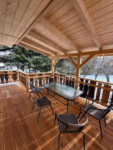 een houten terras met een tafel en stoelen erop bij Markowa Chata in Mizerna