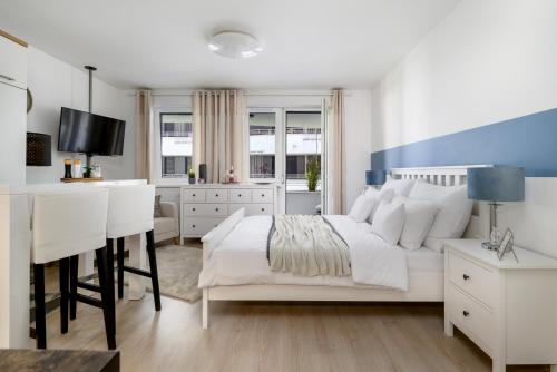 een witte slaapkamer met een bed en een bureau bij Leonardo50 Apartment in Boedapest