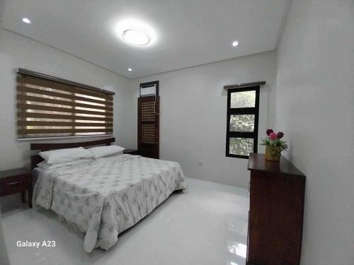 a white bedroom with a bed and a window at Sehaliah Agricultural Farm Resort in Amadeo