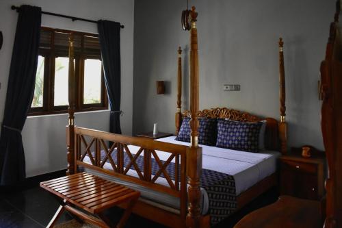 a bedroom with a wooden bed and a wooden chair at BREATHE Collections Habaraduwa in Habaraduwa