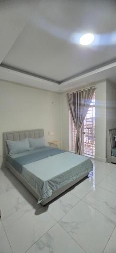 a bedroom with a large bed and a window at SAMBATH SAKSETH Guesthouse in Phumĭ Nésat