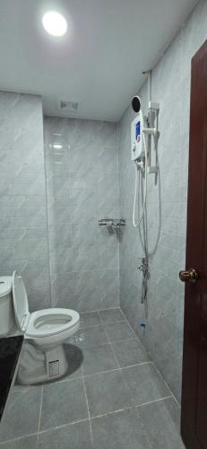 a bathroom with a toilet and a shower stall at SAMBATH SAKSETH Guesthouse in Phumĭ Nésat