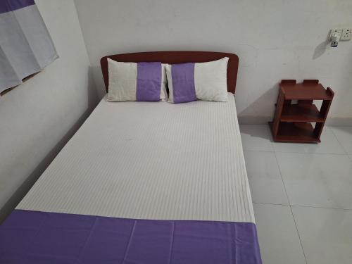 a bed in a room with purple and white at Priya Villa Homestay in Jaffna