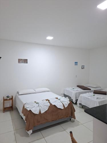 twee bedden in een kamer met witte muren bij pousada beira mar suites São Bento in Maragogi