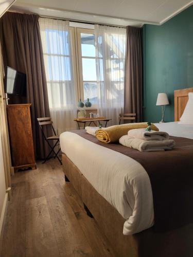 une chambre avec un grand lit et une fenêtre dans l'établissement Hotel Stedswal, à Sloten