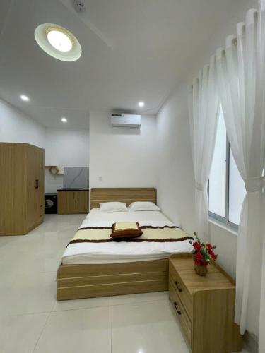a bedroom with a bed and a large window at LAKSHMI Apartment & Hotel Da Nang in Danang