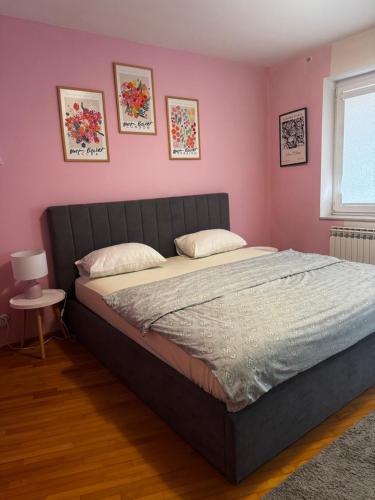 een slaapkamer met een groot bed met roze muren bij Ferhadija Old Town Apartments in Sarajevo