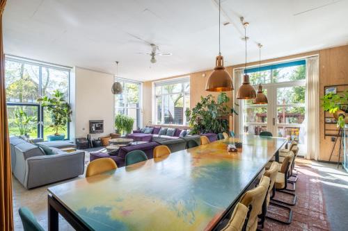een grote woonkamer met een grote tafel en stoelen bij LOFT Groepsaccommodatie in Boxum