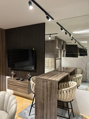a living room with a table with chairs and a tv at Studio Vučko in Pale